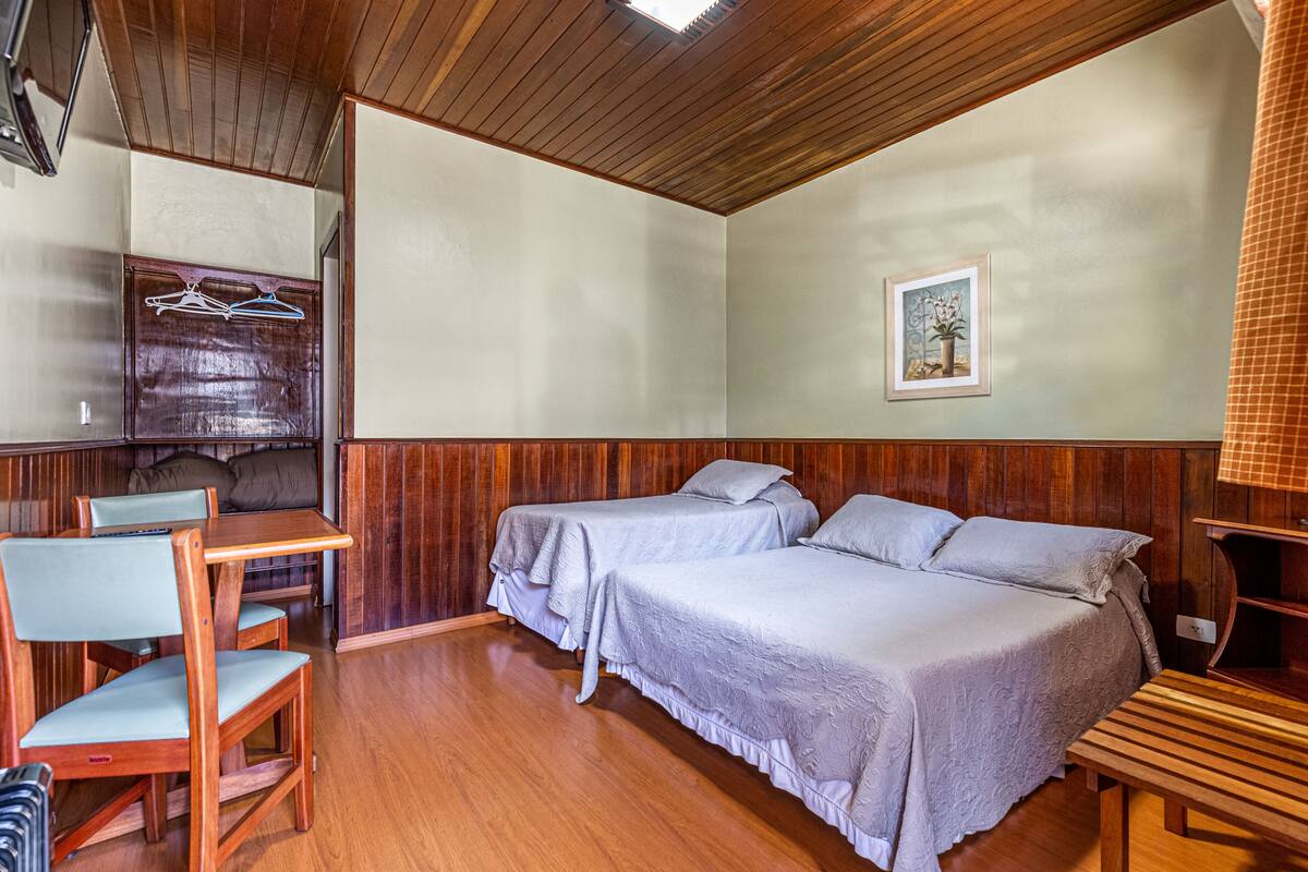 Een kamer met twee bedden, een houten bureau en een bank.