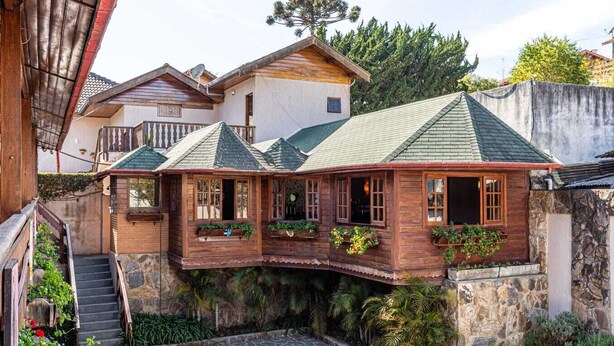 A wooden house with a stone staircase and a stone courtyard. - Pousada Saint Gallen  (Campos do Jordão)