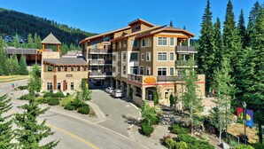 Ein mehrstöckiges Hotel mit einer zentralen Atrium und Balkonen, mit Blick auf den umliegenden Wald.