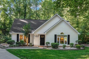 A single-story house with a gabled roof, a front porch, and a well-maintained lawn.
