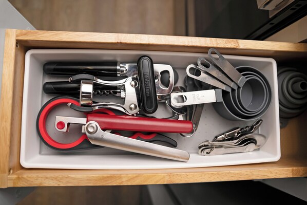 A drawer containing various tools such as pliers, a wrench, and a screwdriver.