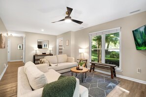 A living room with a sofa, coffee table, and a ceiling fan.