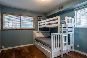 A bunk bed room with a window and a picture frame on the wall.