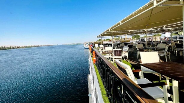 A cruise ship deck with outdoor seating and a view of the water. - Nile Cruise Aswoan & Luxor 3 & 4 Nights (Aswan)