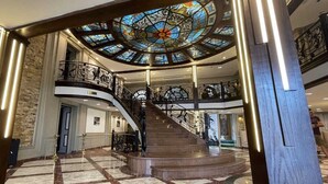 A grand staircase with a glass dome ceiling, marble flooring, and a second-floor balcony with ornate railings. - Nile Cruise Aswoan & Luxor 3 & 4 Nights (Aswan)