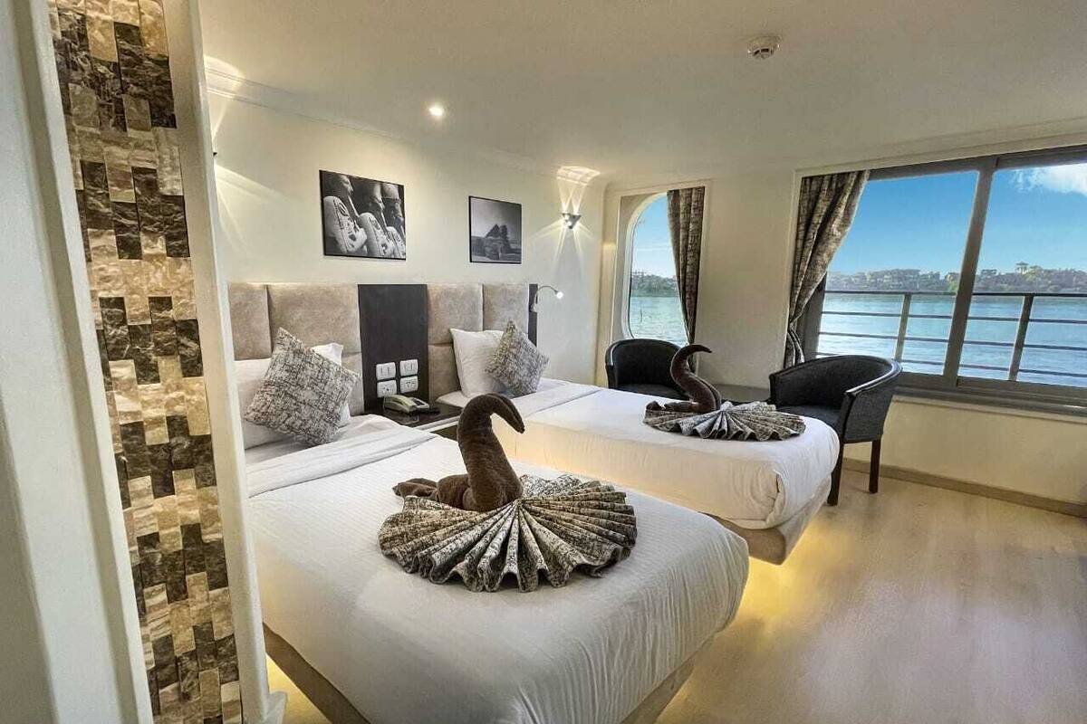 A hotel room with two beds, a view of the sea, and a modern design.