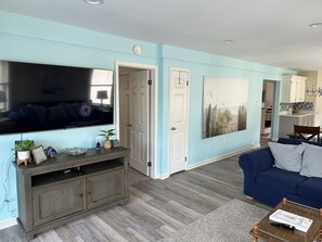 Relax in this stylish living space with a flat-screen TV, entertainment unit, and comfortable sofa.