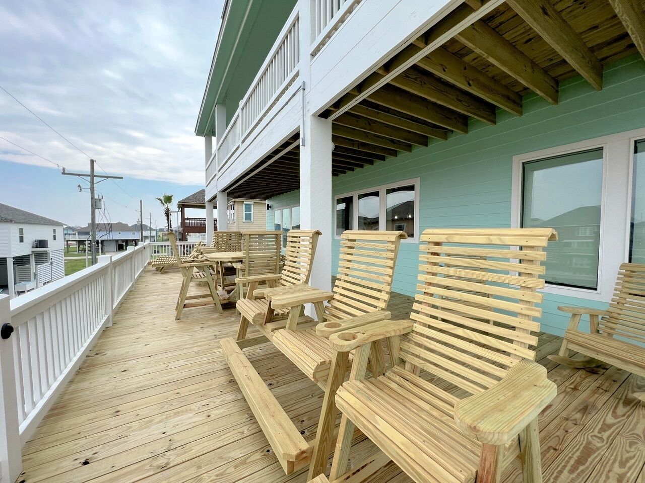 A wooden deck with outdoor seating and a view of the ocean.