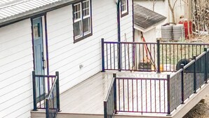 Une maison avec un porche à l’avant, un escalier et une petite terrasse.