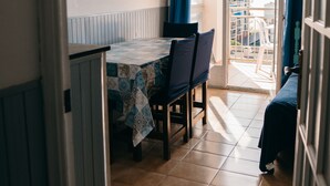 Ein Essbereich mit Tisch, Stühlen und Blick auf den Balkon.