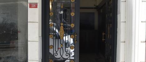 The entrance to Shishly Palace Hotel with a black sign above the door.