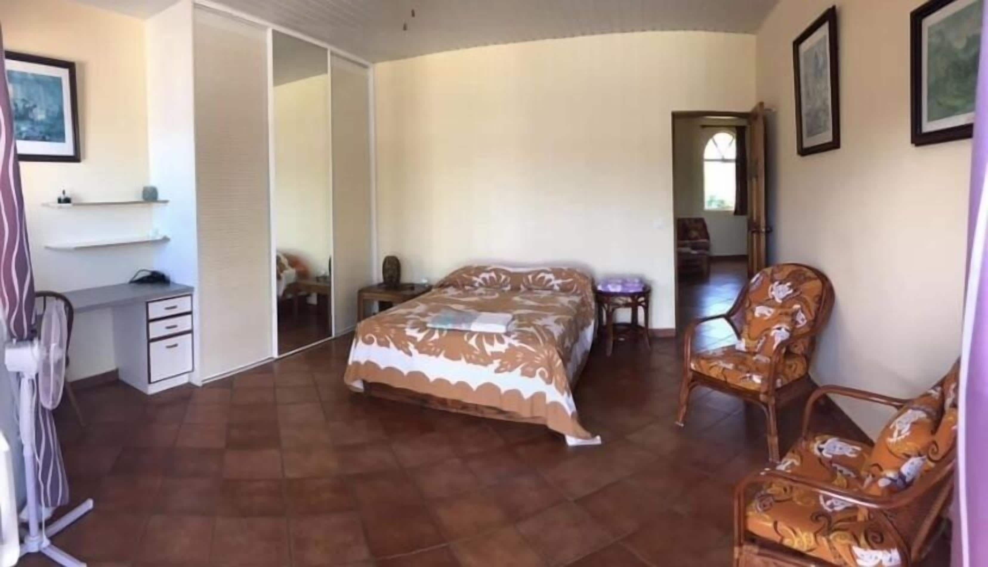 Un dormitorio con cama, escritorio, silla y armario.