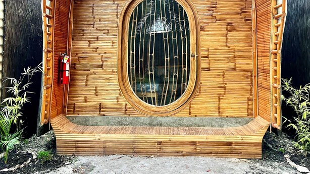 A wooden structure with a circular window and a ramp leading up to it. - The Backyard Inn (Moalboal)