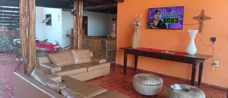 Una sala acogedora con un conjunto de sofás, un televisor montado en la pared y un elemento decorativo.