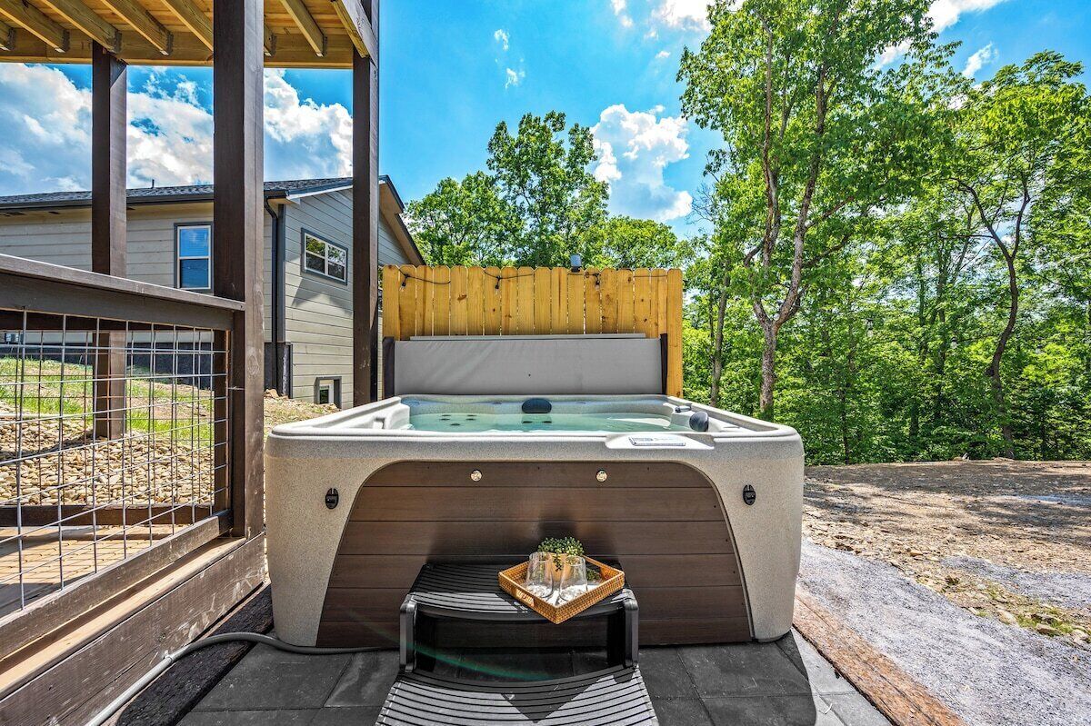 A hot tub with a wooden deck and a small table with a plant.