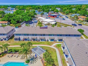 Un hotel su più piani con piscina, area salotto all'aperto e parcheggio.