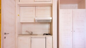 Une cuisine compacte équipée d’un lave-vaisselle, d’un évier et d’une cuisinière.