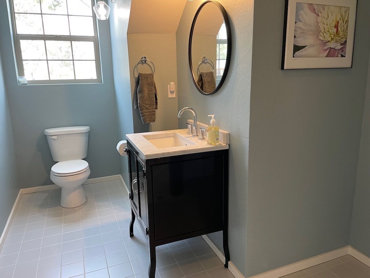 Une salle de bain avec des toilettes, un lavabo et un miroir.