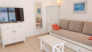A modern living room with a sofa, a TV, a cabinet, and a small table. - Petite Maison (Belgodère)