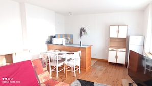 Una cocina compacta con comedor, horno empotrado y refrigerador.