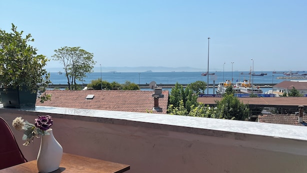 A terrace with a table and chairs, overlooking a coastal area with boats and buildings. - La Vien Hotel Old City (Istanbul)