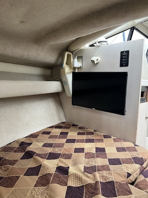 Cozy retreat with a comfortable bed, mounted TV, and convenient power outlet.