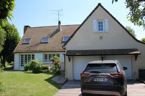 A house with a garage, a car parked in front, and a well-maintained lawn.