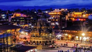 A historic square with a prominent domed building, surrounded by traditional architecture and illuminated by street lights. - MeroStay 154 White & Peace (Lalitpur)