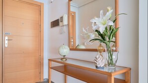 A wooden console table with a globe, a telephone, and a vase with flowers. - iloftmalaga Playa Machado (Málaga)