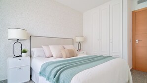 A neatly arranged bedroom with a bed, two bedside tables with lamps, a nightstand, and a wardrobe. - iloftmalaga Playa Machado (Málaga)