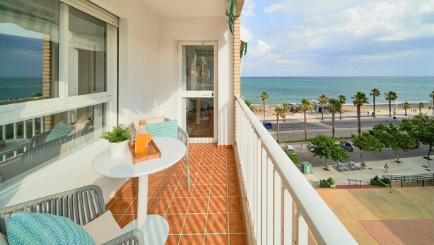 A balcony with a view of the beach, a small table with a plant, and a chair. - iloftmalaga Playa Machado (Málaga)