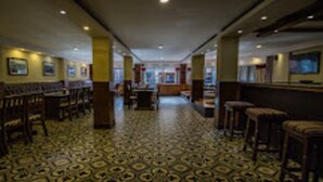 A hotel lobby with patterned flooring, wooden furniture, and framed pictures on the walls. - MeroStay 153 TH (Kathmandu)