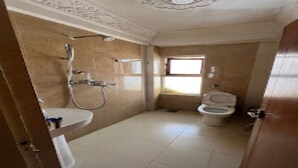 A bathroom with a toilet, sink, and shower. - MeroStay 153 TH (Kathmandu)