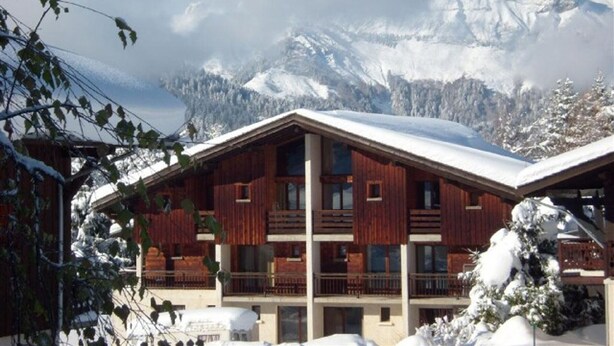 A wooden chalet with a balcony, surrounded by snow-covered mountains. - Studio cabin for 4 with parking in Crest-Voland (Crest-Voland)