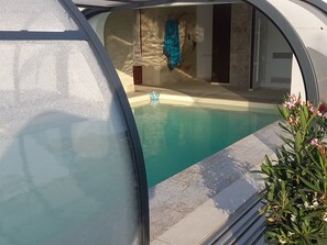 A modern pool area with a clear view of the pool, a blue towel, and a small decorative item on the pool edge.