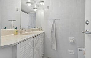 Un baño moderno con dos lavamanos, un espejo grande y una toalla colgada en la pared.