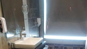 A bathroom with a toilet, sink, and shower area. - Redwood Resort (Panchkula)