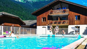 A wooden chalet with a pool, surrounded by mountains. - Bel Appartement Avec Piscine - Le Grand Tétras (Samoëns)