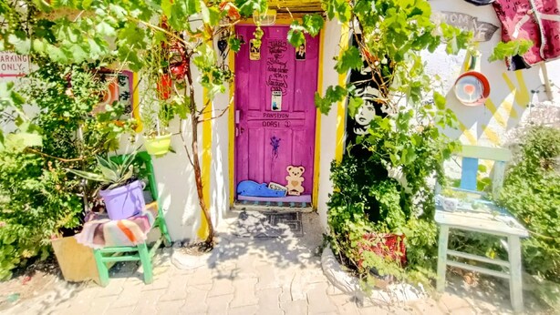 A colorful entrance with a purple door, a small bench, and a chair outside. - Mell10 House (Urla)
