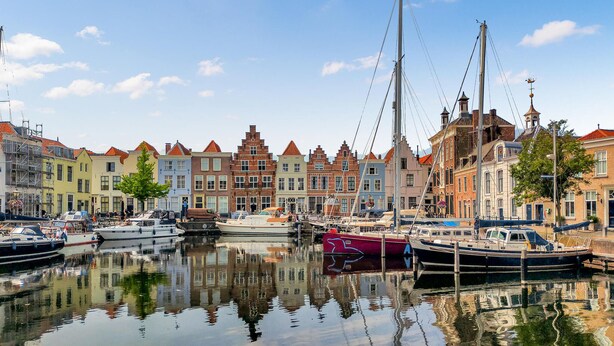 A marina with boats docked, surrounded by historic buildings with varied architectural styles. - Stunning home in Heinkenszand with WiFi (Heinkenszand)