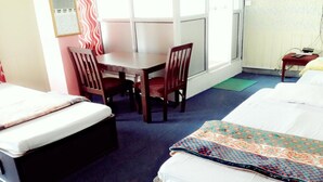 A hotel room with a bed, a desk, two chairs, and a small table. - Merostay 158 Hotel RM (Kathmandu)