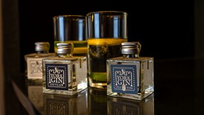 Three bottles of "New York Gin" and two glasses on a reflective surface. - An exquisite, brand new studio right in the heart of the city centre (York)