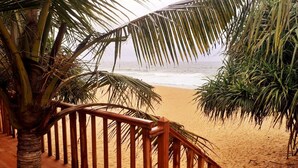 A wooden staircase leading to a beach with palm trees.