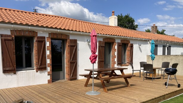 Eine Terrasse mit Holzdeck, Grill und Gartenm öbeln.