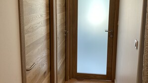Ein Flur mit Holztüren und gefliestem Boden.