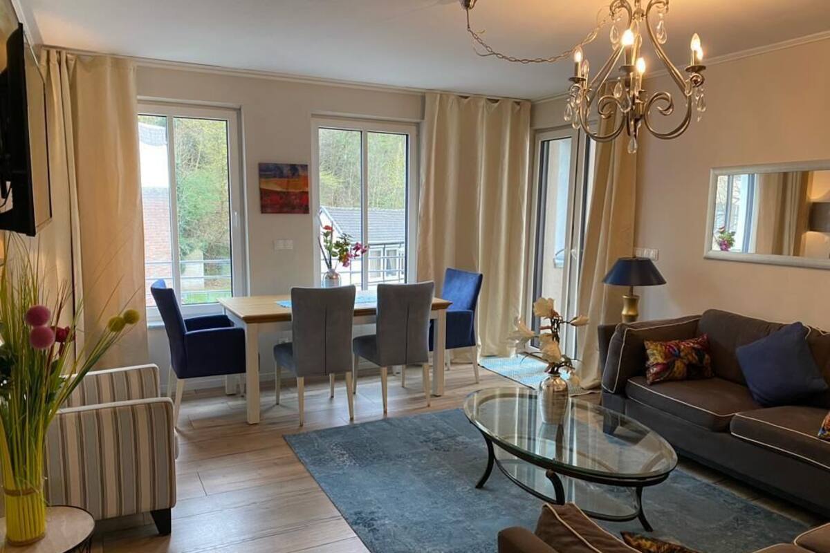 Uma sala de estar moderna com sofá, mesa de centro e área de refeições.