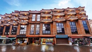 A multi-story building with a brick facade, large windows, and multiple balconies. - MeroStay 253 GT Hotel (Kathmandu)
