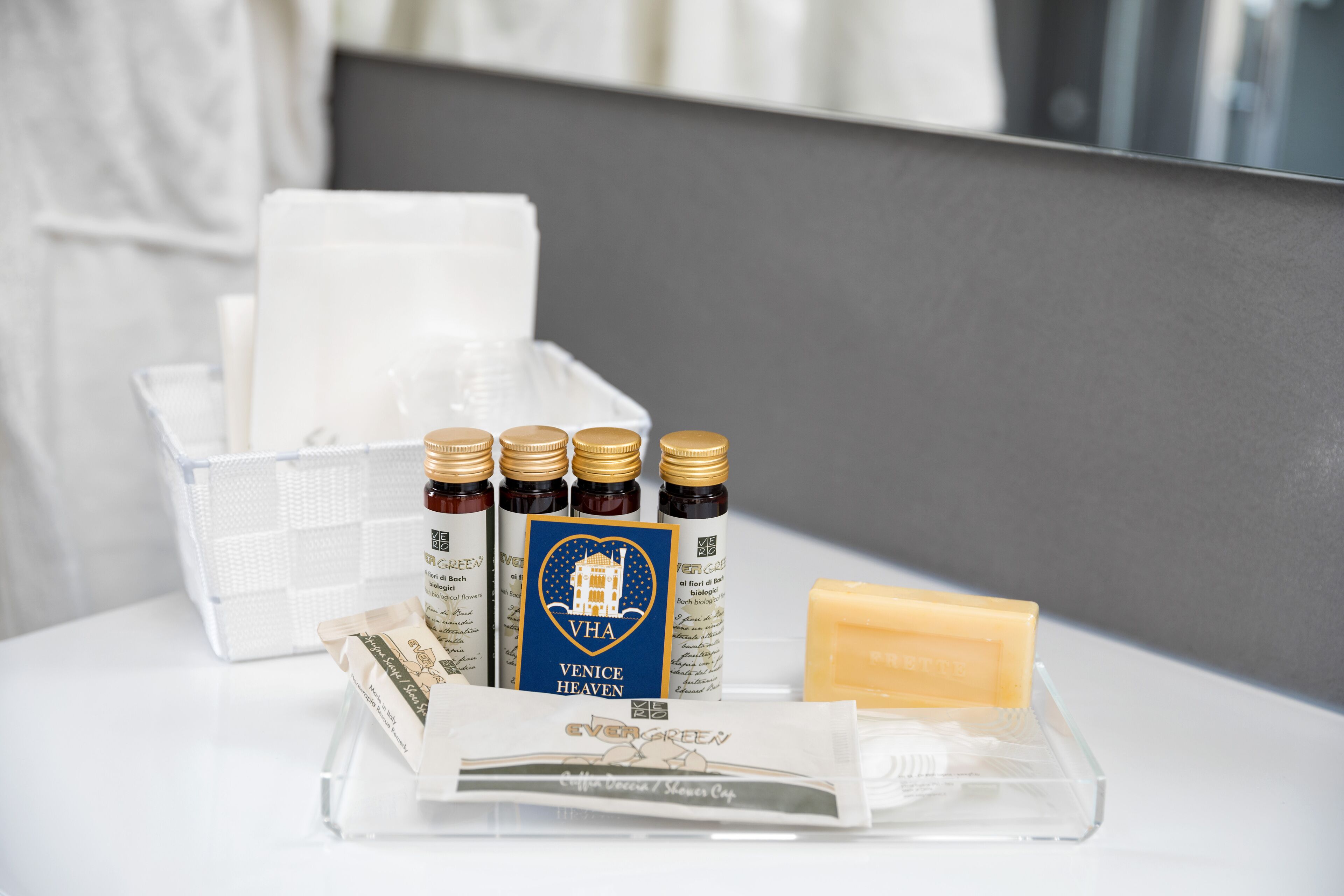 A bathroom counter with toiletries including bottles, a bar of soap, and a tissue box.