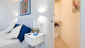 Un dormitorio con cama, mesita de noche y decoración en la pared.