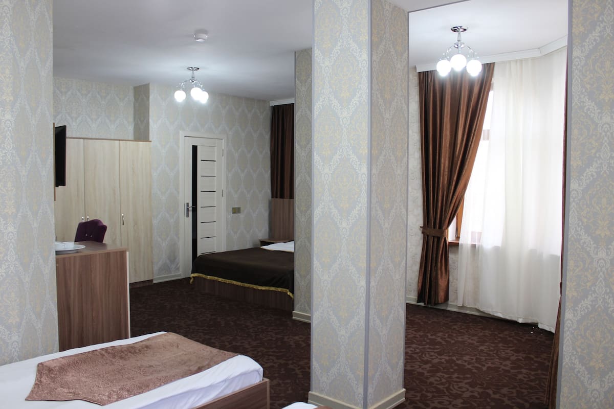 A hotel room with a bed, a desk, a wardrobe, and a bathroom.